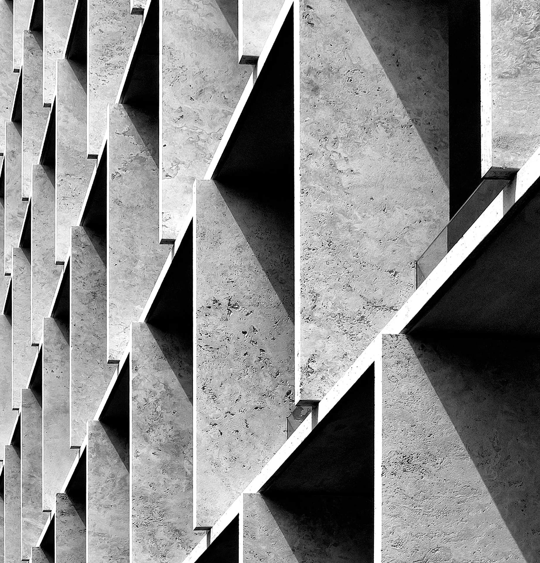 Sculptural concrete facade with geometric fins and deep angular shadows